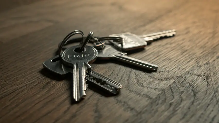 A bunch of keys lying on a wooden table.