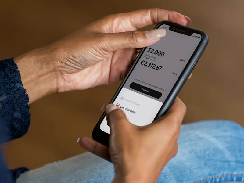 Hands holding a phone showing a payment amount.