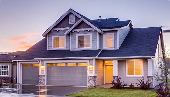 An example rental listing photo: a two-storey house at dusk with the porch light on.
